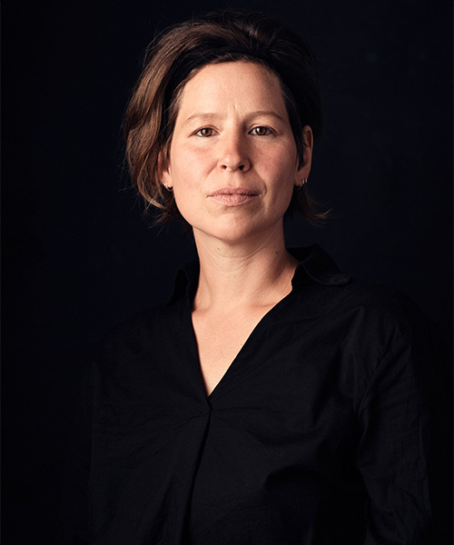Porträt von Susanne Kaiser mit entschlossenem Blick vor einem dunklen Hintergrund